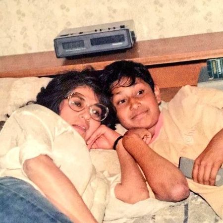 Young Tenoch Huerta laying in a bed alongside his mother.